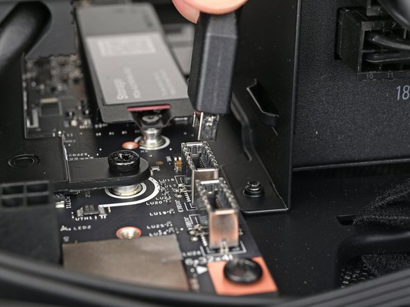 Slide the USB port cable into one of the USB Type-E 20-pin sockets above the primary storage.