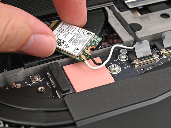 Rotate the Wi-Fi Module back into place, making sure the antenna cables wrap around their silver peg on the Mainboard and tuck underneath the heat sink.