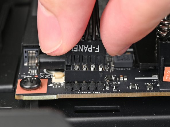 Slide the front panel header cable into its 9-pin connector underneath the primary storage.
