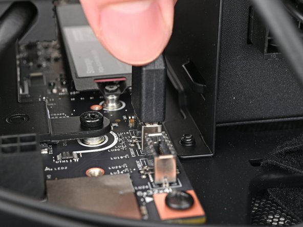 Slide the USB port cable into one of the USB Type-E 20-pin sockets above the primary storage.