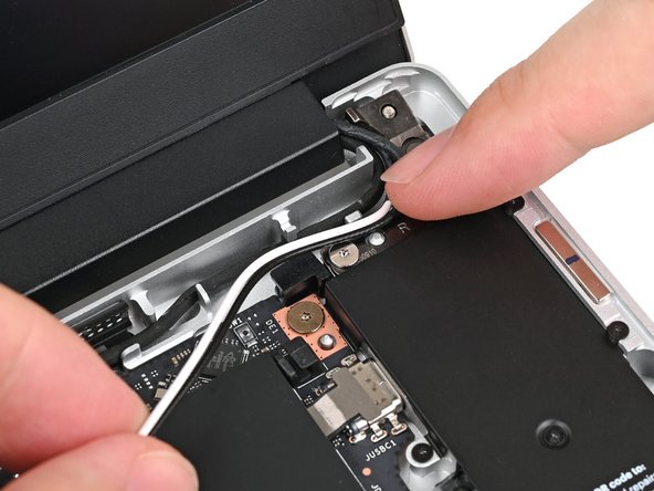 Use your finger to press the Antenna Cables into their metal clip on the Bottom Cover.