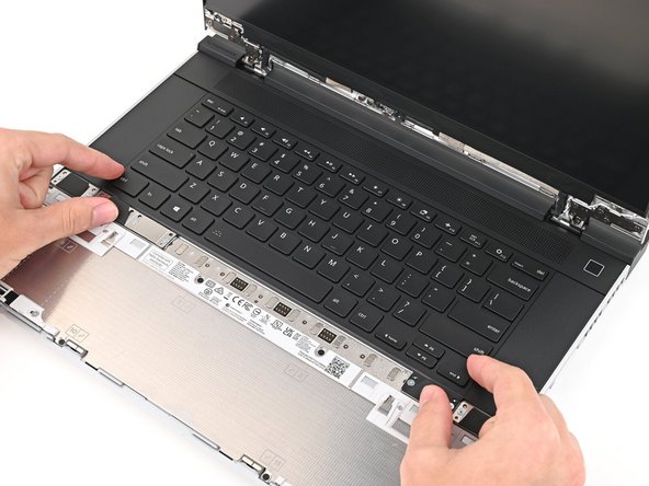Slide the top lip of the keyboard underneath the ventilation plate and lay the keyboard down flat to let the magnets pull it into place.