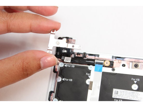 Place the silver bracket over the Fingerprint Reader so that the three fastener holes align with the fastener holes on the module.