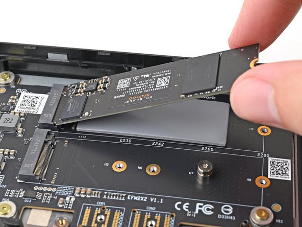 Insert the SSD into the socket at a shallow angle. The gold contacts should mostly be covered by the socket.