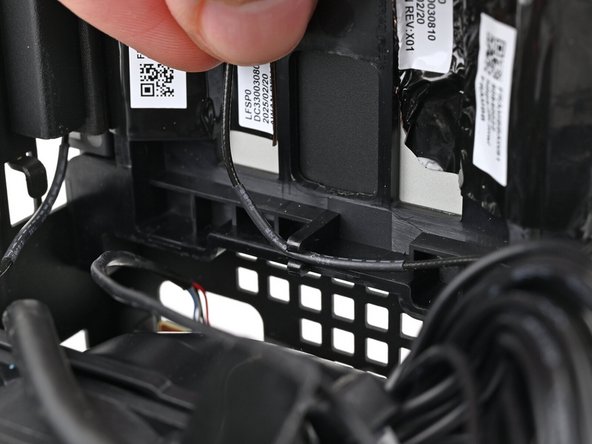 Pull the black antenna cable out of the plastic clip in the chassis.