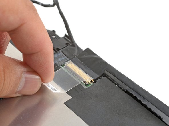 Use your fingers to peel up the clear tab covering the display cable connector.