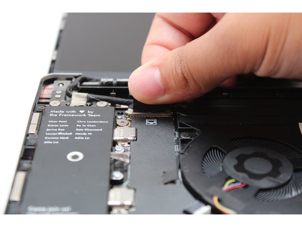 Find the black Display Cable that connects the display to the mainboard. Unplug the cable by pulling it directly upwards using the black pull tab.