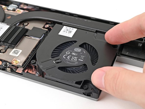 Place the fan onto the Expansion Bay Shell, making sure to thread the cable through its slot.