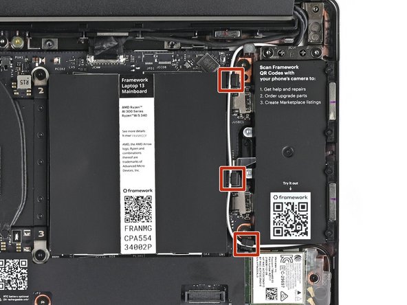 Use the flat end of your Framework Screwdriver to press the two antenna cables into their rubber clips on the Mainboard.