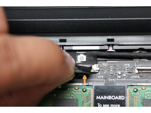 Using your fingers, carefully disconnect the Webcam cable on the top, right hand side by using the black pull tab to pull it directly upward.