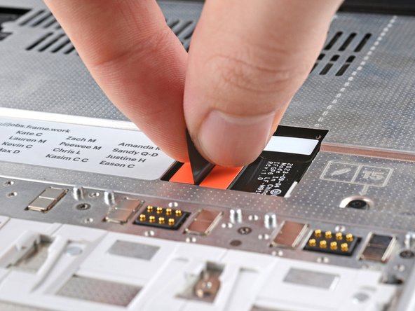 Grip the black pull tab on the Mid Plate cable press connector and lift up to disconnect it.