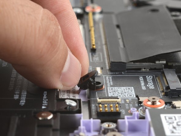 Align the SSD clip with its screw hole and set its two pins into their slots on the Mainboard.