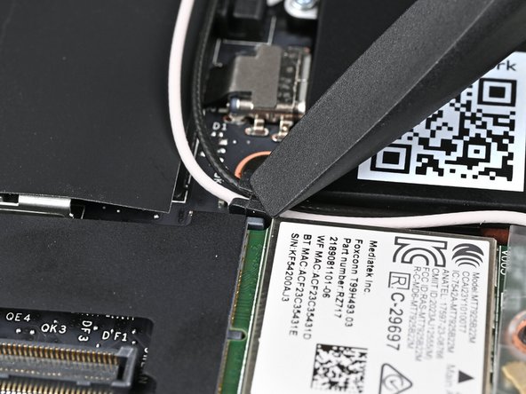 Use the flat end of your Framework Screwdriver to press the two antenna cables into their rubber clips on the Mainboard.