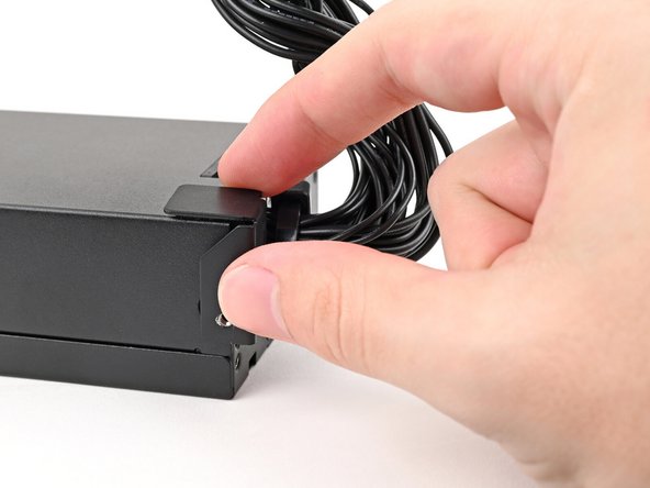 Place the mounting bracket on the corner of the power supply closest to the wire bundle.