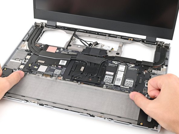 Use your fingers to lift the bottom edge of the Mainboard enough to grip its edges.