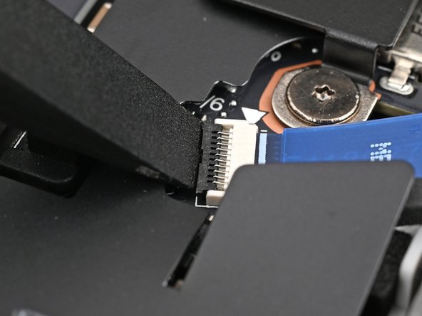 Use the flat end of a spudger, or a clean fingernail, to lift up the locking tab on the fingerprint sensor ZIF connector next to the memory.