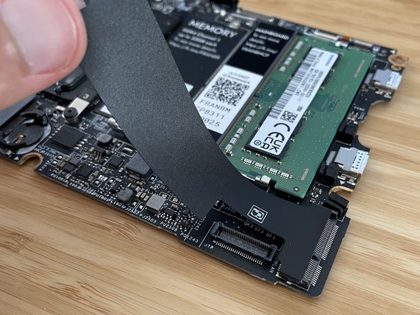 Peel back and remove the black mylar cover that is to the right of the coin cell socket.  Set it aside, as you will need to re-use it later.