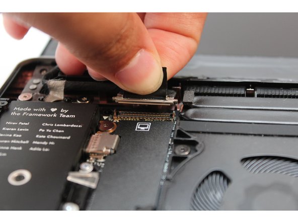 Hold the pull tab on the Display cable and connect it into the Mainboard by aligning the pins from the cable with the socket pins on the Mainboard.