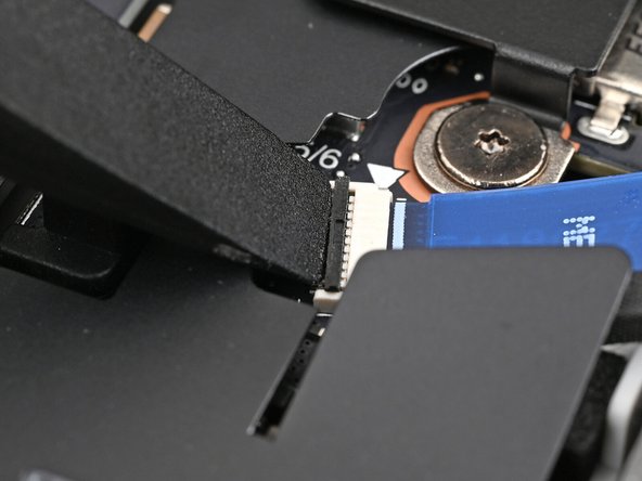 Use the flat end of a spudger, or a clean fingernail, to lift up the locking tab on the fingerprint sensor ZIF connector next to the memory.