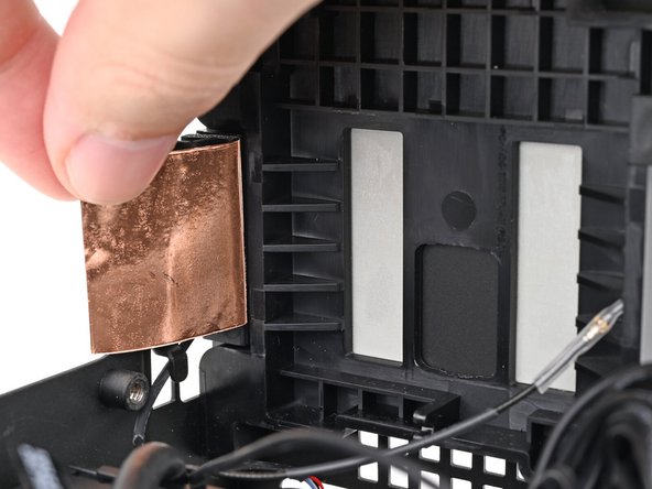 Press the right antenna's copper film onto the chassis and adhere it.