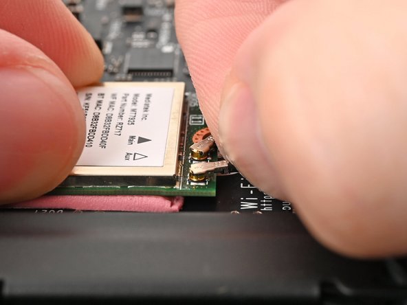 The Wi-Fi module has two delicate coaxial cable connectors. Follow this step carefully to avoid damaging them.