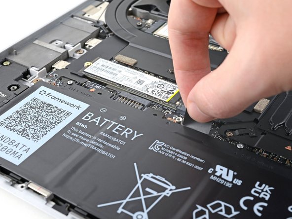 Grip the black pull tab at the top of the battery and lift to disconnect the battery connector.