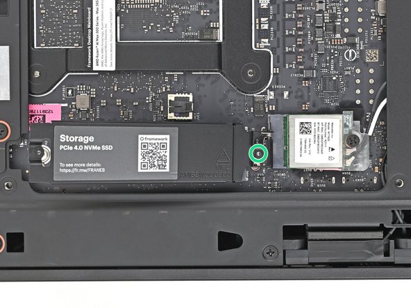 While securing the secondary storage heat spreader with one hand, use your Framework Desktop Screwdriver to remove the 4.5 mm‑long T5 Torx screw securing it.