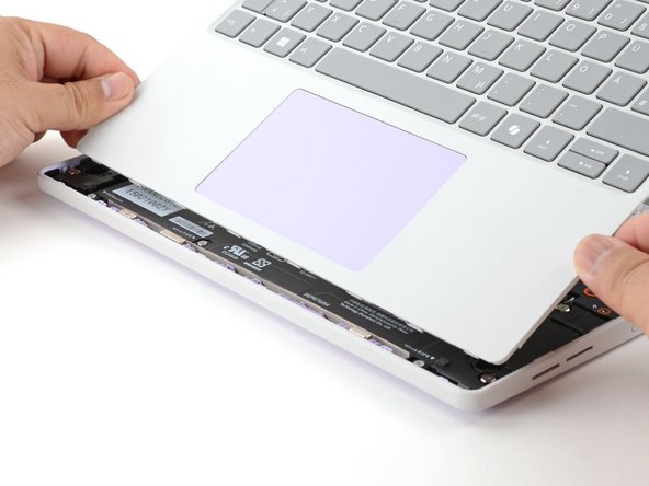 Angle the bottom edge of the Input Cover towards the base of the laptop.