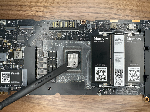 Using the spudger, remove the liquid metal from the CPU die.