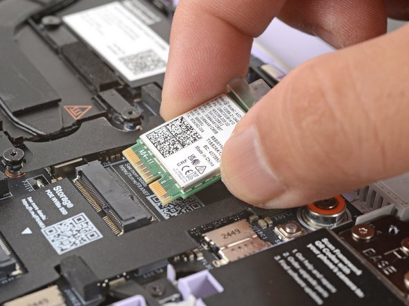 Grab the Wi-Fi card by its edges and slide it out of its socket.