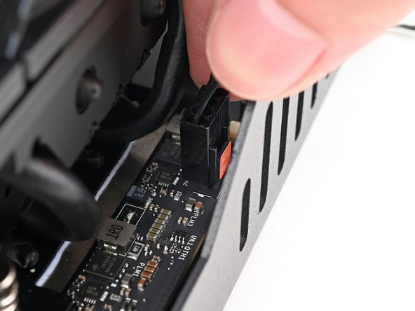 Slide the main fan cable over the four-pronged connector labeled &quot;APU Fan,&quot; making sure the orange label slots between the vertical lines.