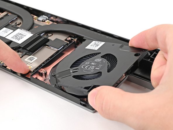 Use your other hand to pull the fan out of its housing, making sure to thread the cable though its slot.