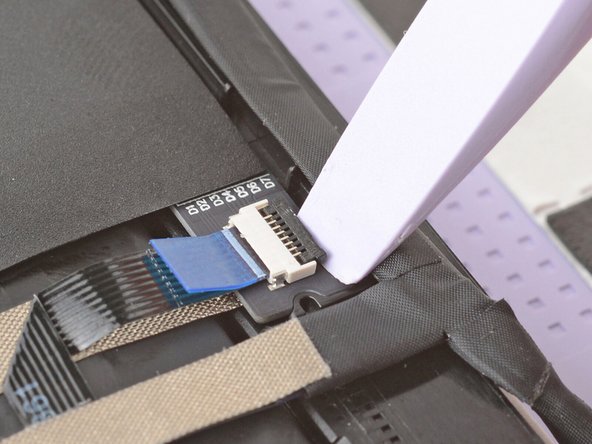 Use the flat end of your Framework Screwdriver or a fingernail to gently pry up the locking tab on the touch control ZIF connector near the hinge edge of the display.