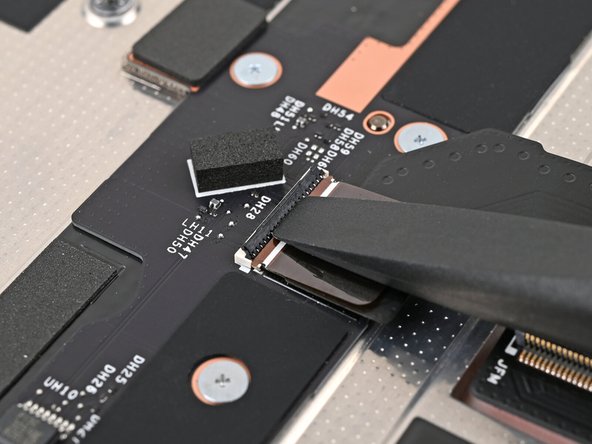 Use the flat end of the Framework Screwdriver, or a clean fingernail, to lift up the locking tab on the Mid Plate Cable ZIF connector.