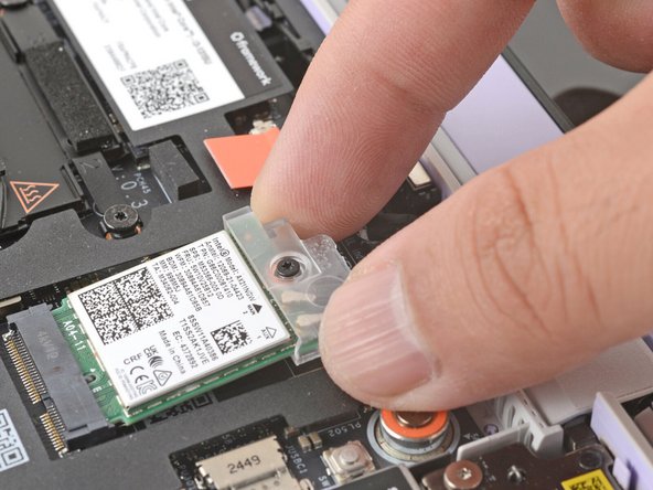 Grab the Wi-Fi card bracket with your fingers and slide it off the top of the Wi-Fi card.