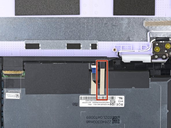Slide the flat end of your Framework Screwdriver under the grounding tape securing the display cable.