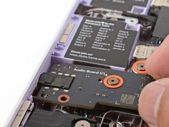 Use your fingers to lift the right edge of the Audio Board and pull it out of its recess.