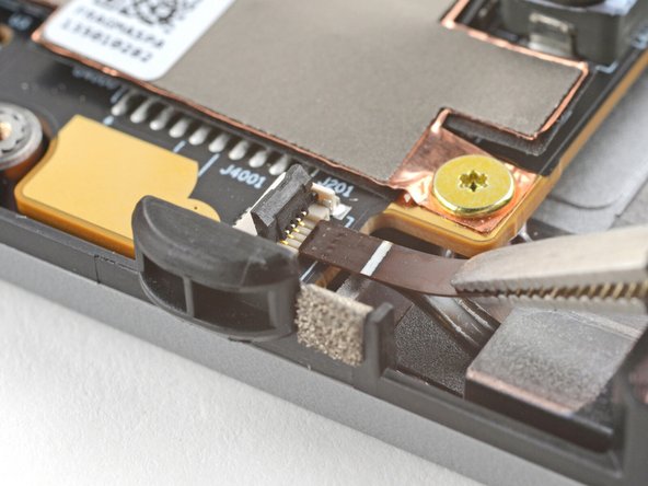 Use tweezers, or your fingers, to grip the brown pull tab and slide the fan cable straight out of its socket.