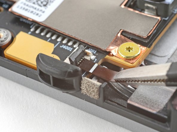 Use tweezers, or your fingers, to grip the brown pull tab and slide the fan cable straight out of its socket.