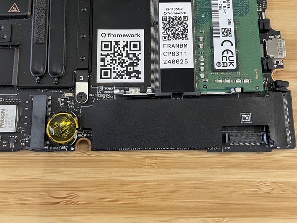 Using your soldering iron and a very small amount of solder, solder the wire onto the right side of the capacitor.  Use a magnifying glass or microscope to check that the solder connection is good and that there isn't excess solder bridging to a different area.