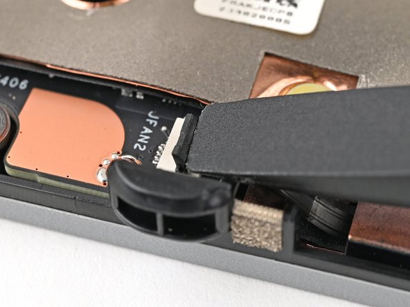 Use your fingers to grip the brown pull tab and slide the fan cable straight out of its socket.