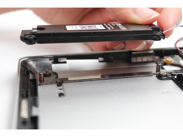 Place both the Left and Right speakers in their respective spaces on the Bottom Cover by aligning the pegs with the rubber gaskets.