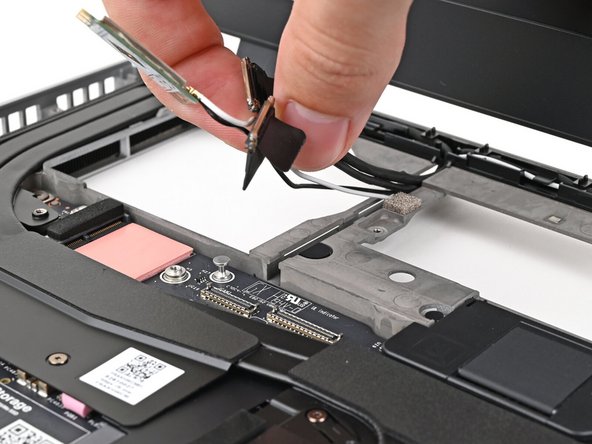 Route the display, webcam, and Wi-Fi module cables into their slots in the frame.