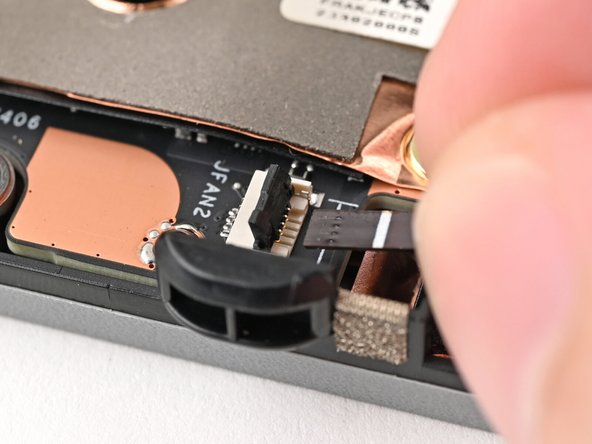 Use your fingers to grip the brown pull tab and slide the fan cable straight out of its socket.