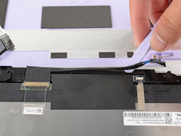 The display cable is lightly adhered to the bottom edge of the display.