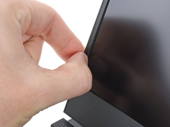 Slide your fingernail under the inside edge of either bottom corner of the bezel.