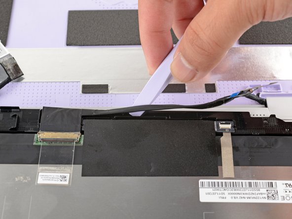 Slide the flat end of your Framework Screwdriver under the length of the display cable to separate it from the display.