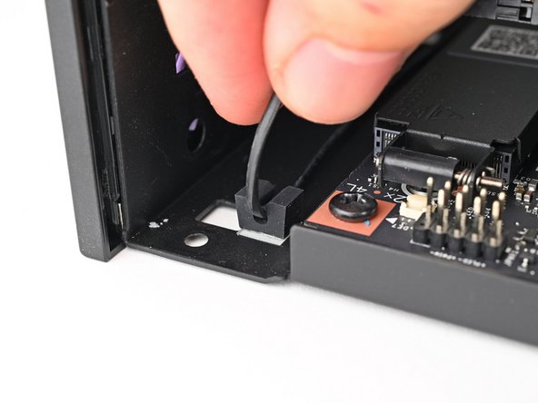 Pull the power button cable out of its rubber clips in the chassis.
