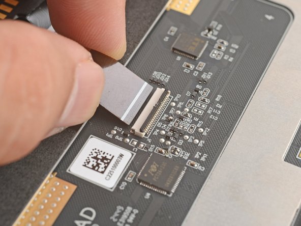 Slide the touchpad ZIF cable into its connector, up to the printed line on the cable.