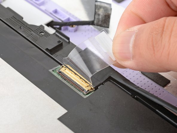Use your fingers to peel up the clear tab covering the display cable connector.
